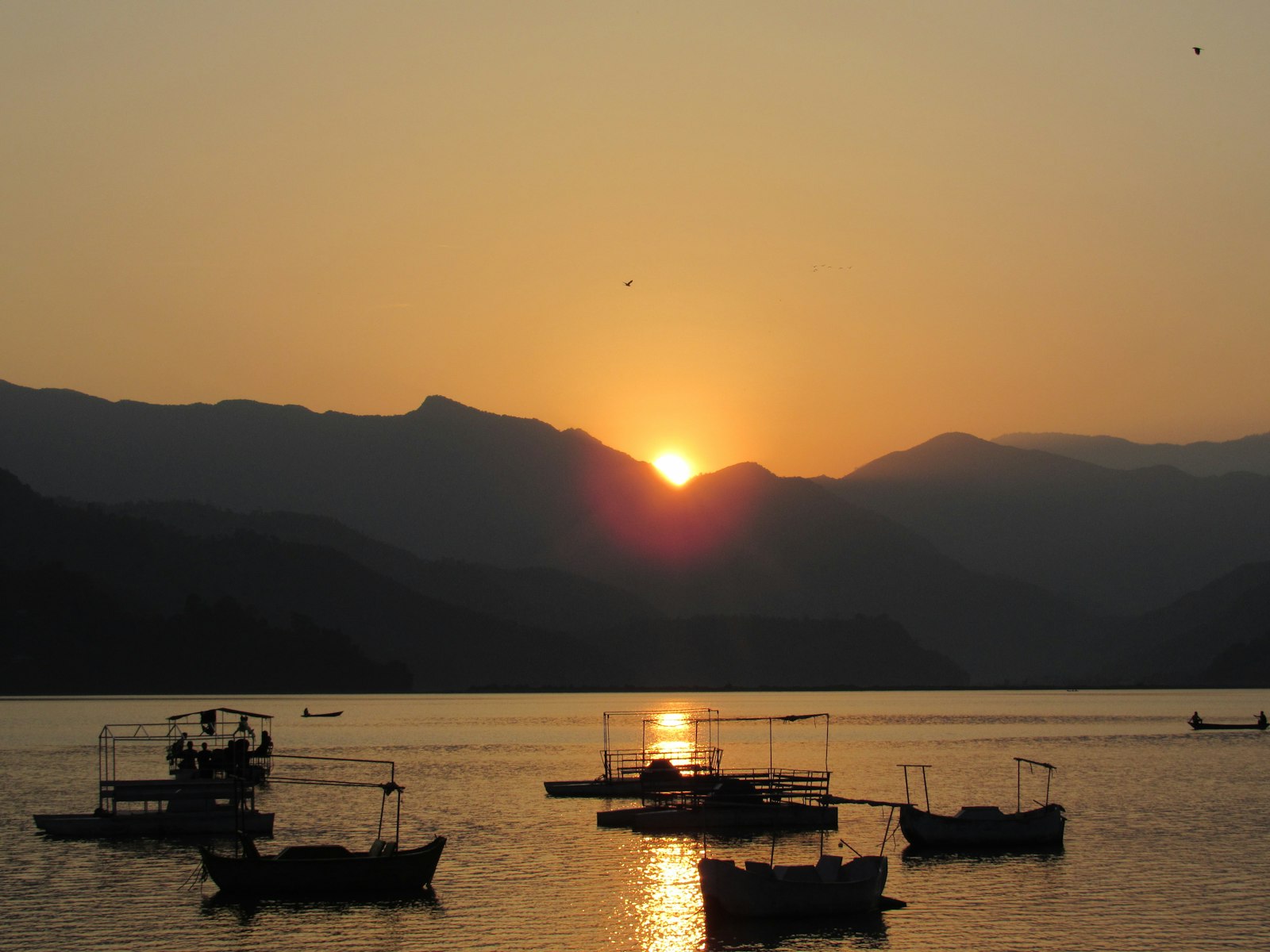 Phewa Lake boat rides at sunset with mountain reflections